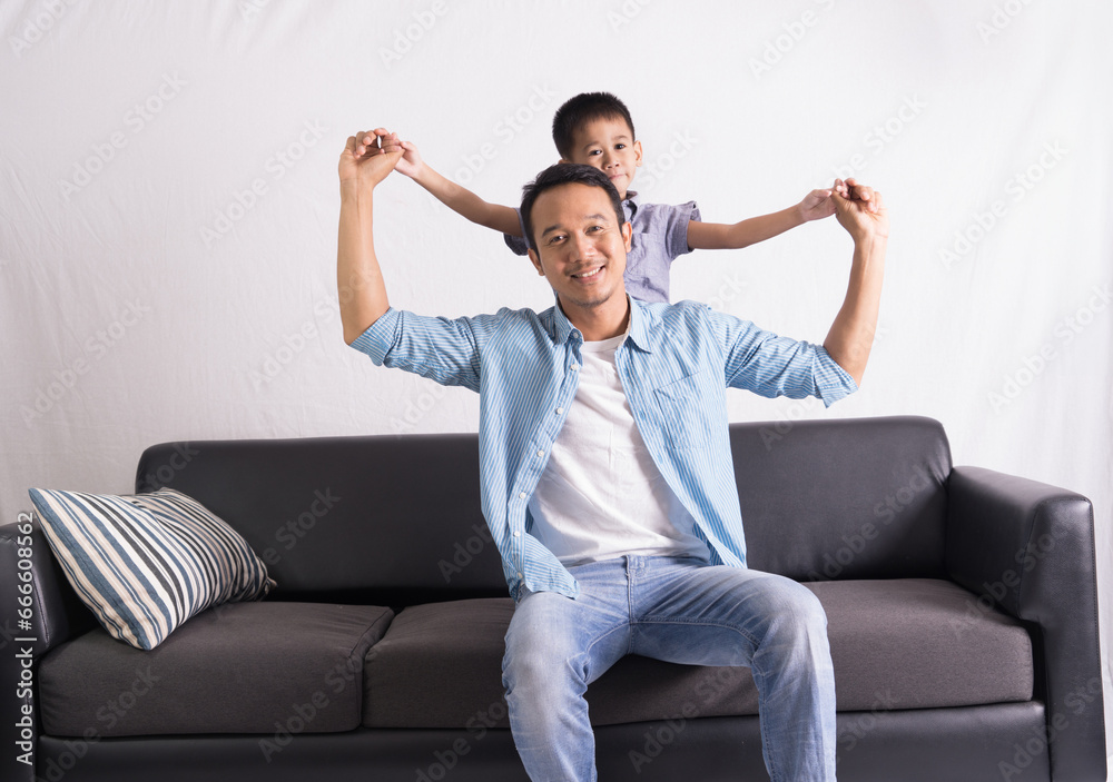 happy asian Father and son are sitting on the couch. Cute boy with dad playing at home. happy family, father day