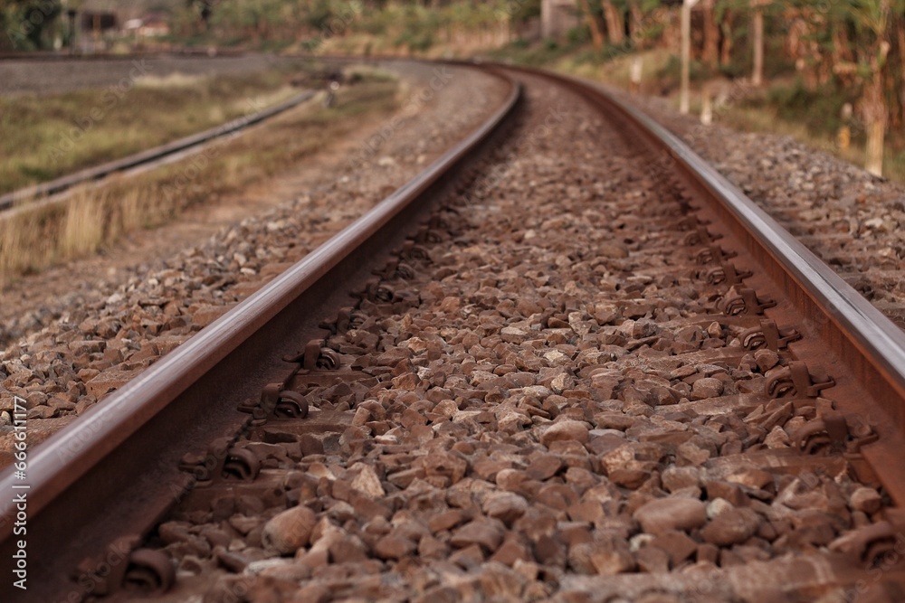 Photo of railroad tracks running diagonally through the picture with partially visible platform as concept for direction travel sadness and loneliness
