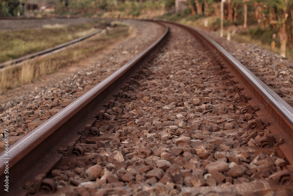 Obraz premium Photo of railroad tracks running diagonally through the picture with partially visible platform as concept for direction travel sadness and loneliness