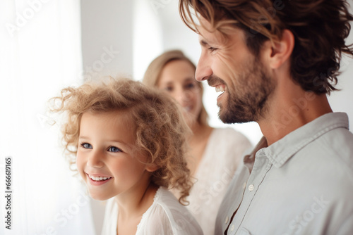 Side View Portrait of Parents and child lined up with a smile and a textured white background