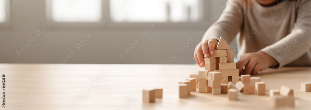 Kid playing with colorful wooden toy blocks. Little boy or girl building tower of block toys. Educational and creative toys and games for young children. Baby in white bedroom Copy space - obrazy, fototapety, plakaty 