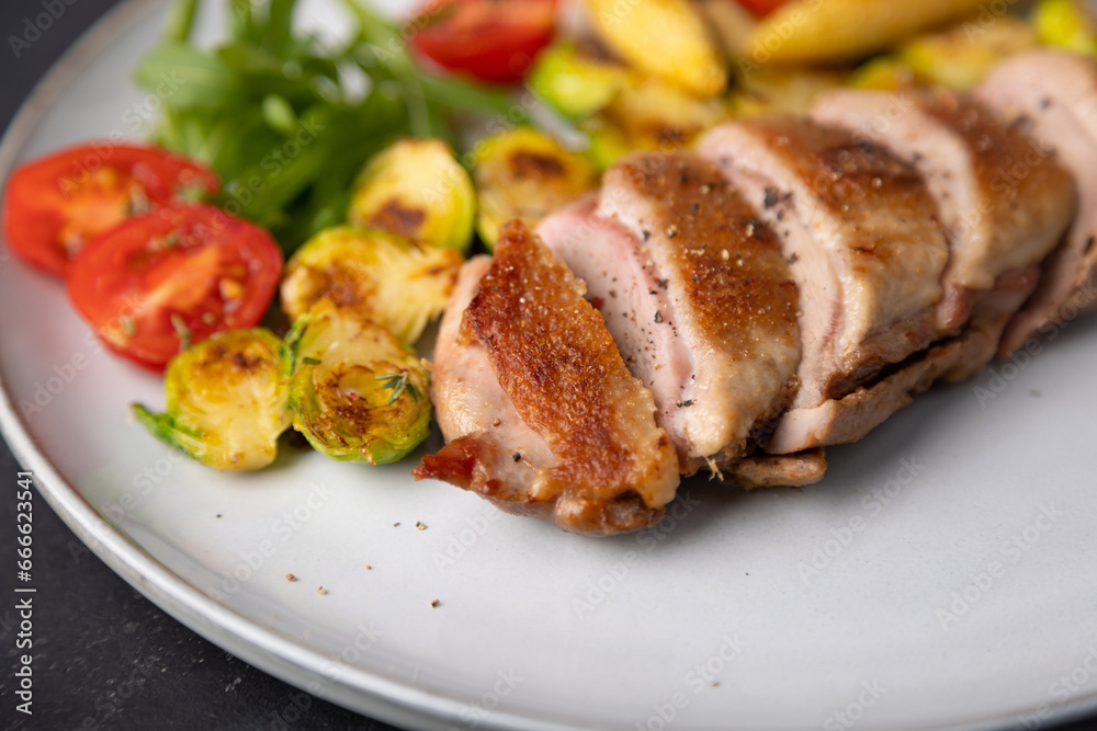 Grilled duck breast fillet with Brussels sprouts, mini corn, cherry tomatoes and arugula. Traditional Mediterranean cuisine. Selective focus, close-up. Grilled duck breast fillet with Brussels sprouts, mini corn, cherry tomatoes and arugula. Traditional Mediterranean cuisine. Selective focus, close-up.