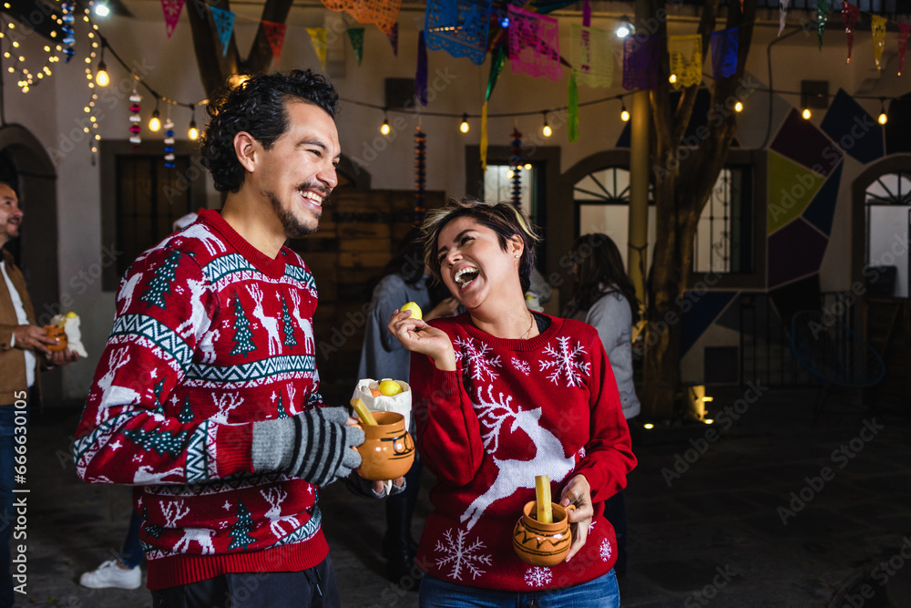 Mexican young couple or friends having fun in posada celebration for Christmas in Mexico Latin America	
