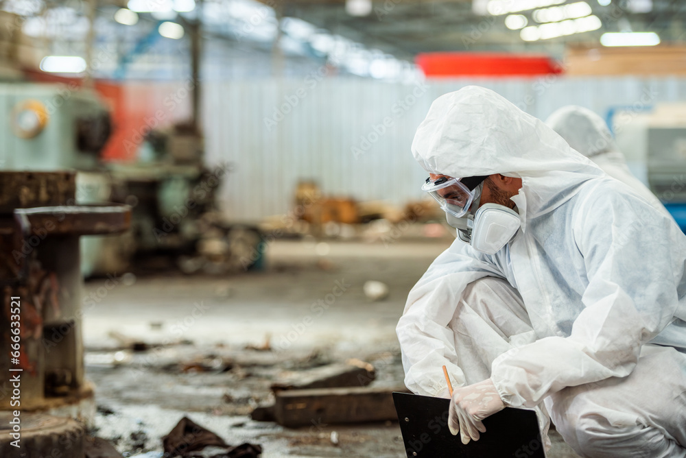 Male inspector team investigate danger chemical gas leak spill with safety face mask PPE suit in area closed barricade security tape. danger dirty area infected chemical leak spill cross stripe ribbon