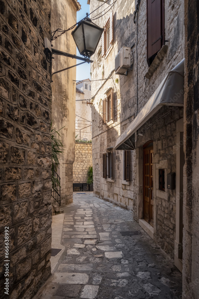 Morning walk along a romantic narrow street in the old town of Trogir on the Adriatic coast, Dalmatia, Croatia