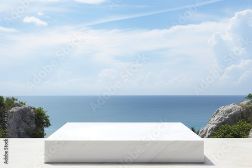 Empty white square marble podium with a view of the sea