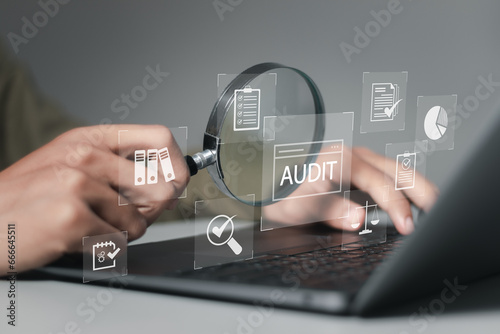 Businessman using laptop computer to audit and evaluate corporate financial statements for Audit business concept. Auditing financial accounts within the organization. photo