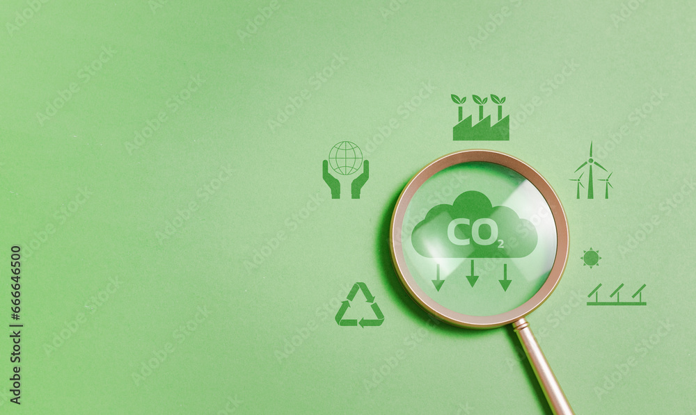 Magnifying glass with reduce CO2 emissions carbon symbol on green background for climate change to limit global warming and sustainable development and green business concept - obrazy, fototapety, plakaty 
