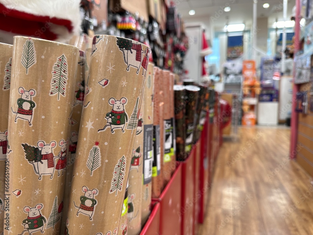 Selective focus on christmas wrapping paper, crafts shop interior on background