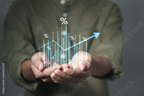 Businessman holding growth graph with percent symbol for increase in interest rates and dividends, return on stocks and mutual funds, long term Investments for retirement photo