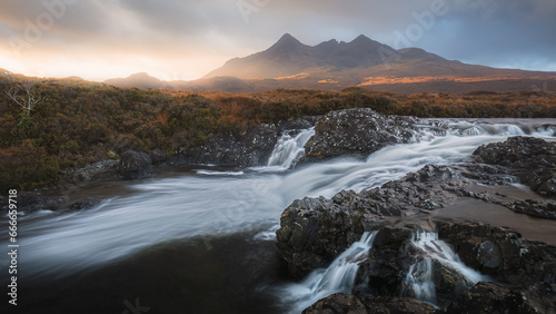 A dramatic view of the old bridge at Sligachan as the river runs beneath and the Cuillin Mountains loom large in the background.