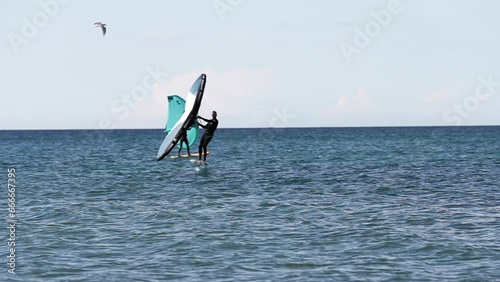 Modern water sport. Hydrofoil ride on the ocean using the wing and the power of the wind. the best place for kitesurfers, video of fit athlete practise hydro foil wing surfing  photo