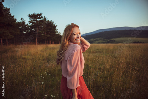 Carefree young woman on a nature field photo