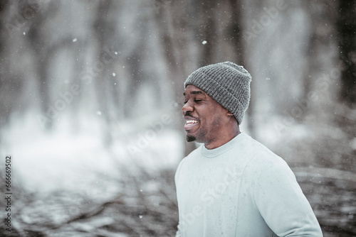 Happy young man working out in park during winter photo