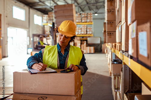 Female worker writing down inventory in a warehouse