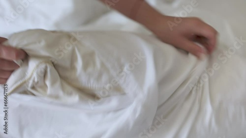 Female hands make bed linen, changes pillowcase. Concept of housework and housekeeping or hotel service.