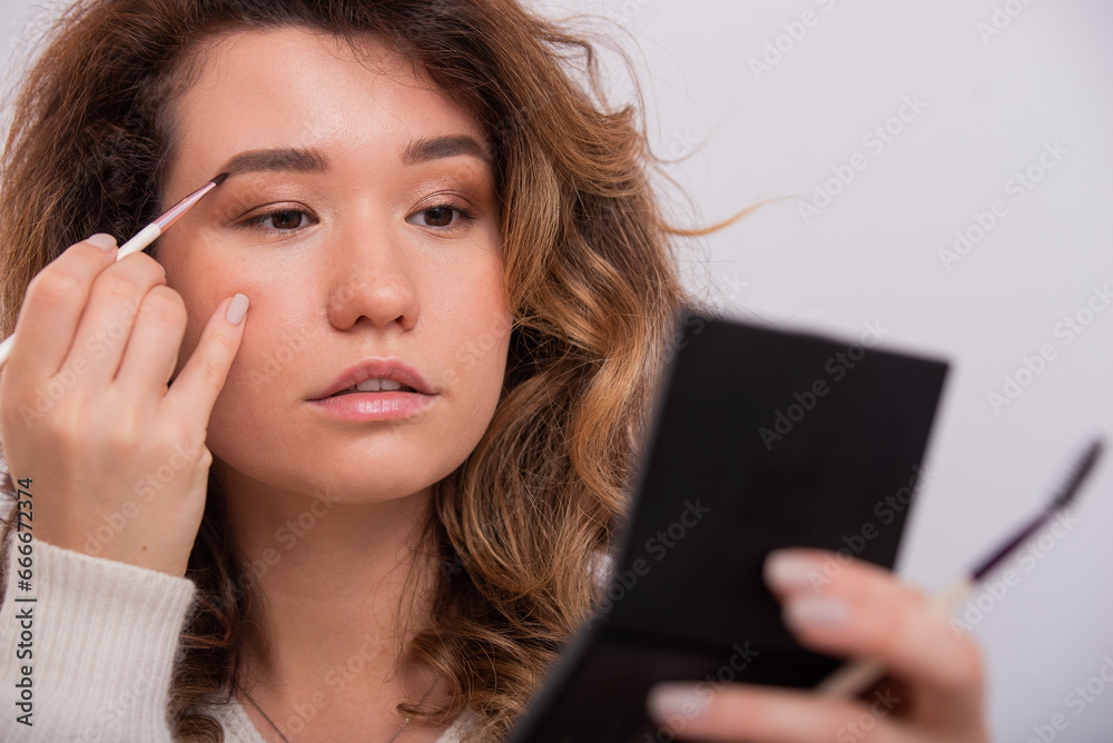 Portrait of a Caucasian young woman doing makeup. Portrait of a Caucasian young woman doing makeup.