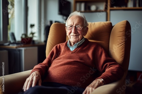 Elderly man in burgundy armchair watching TV in his room - middle shot portrait photo