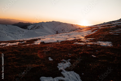 Winter mountain landscape: dawn in the mountains, snow-covered valley, clear sky. High-quality photo for website design, postcards, banners, and travel product advertising.