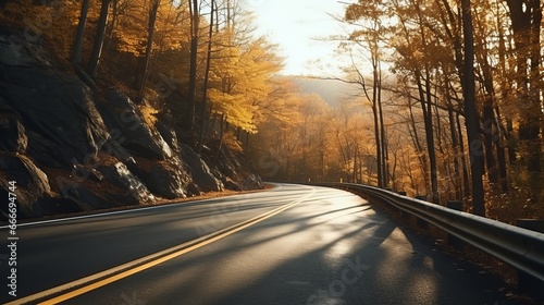 After rain, a scenic mountain road winds through an autumn forest. The road is made of asphalt and features empty hills surrounded by forests. This road landscape is cinematic.
