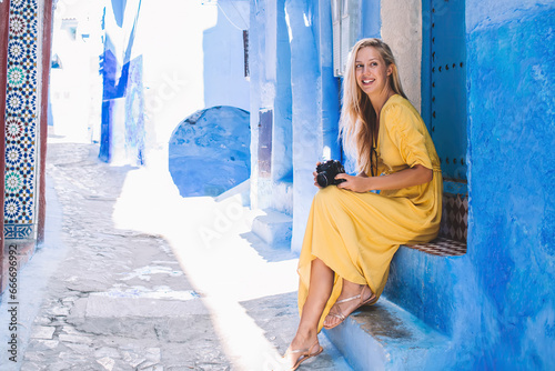 Cheerful tourist with camera resting on narrow street © BullRun