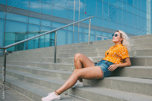 Stylish female resting on street staircase