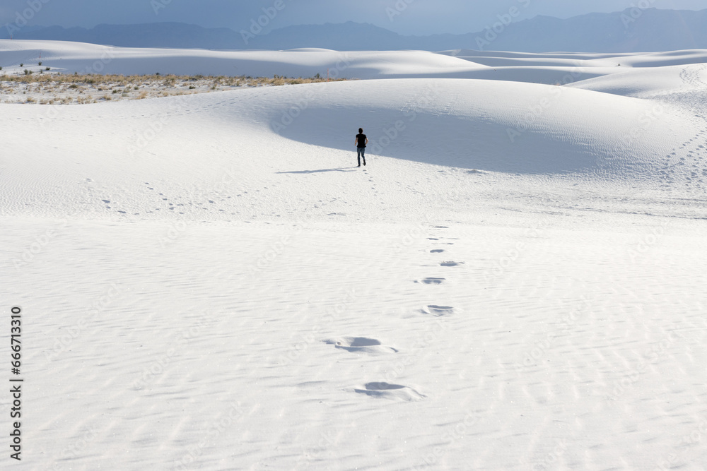 Young man running off into the distance at White Sands National Park