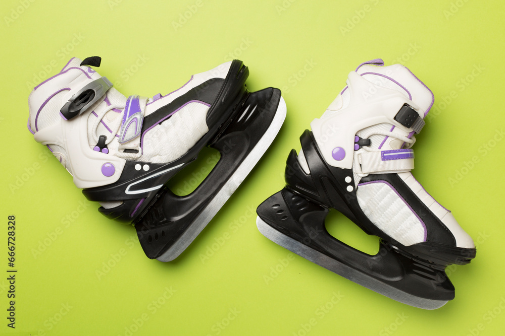 Ice skates on color background, top view