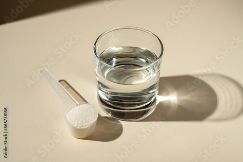 Photography Collagen protein powder scoop and a glass of water