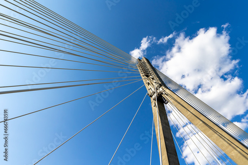 Fixing the ropes in the concrete pylon of the rope bridge. View of the bridge structures against the blue sky