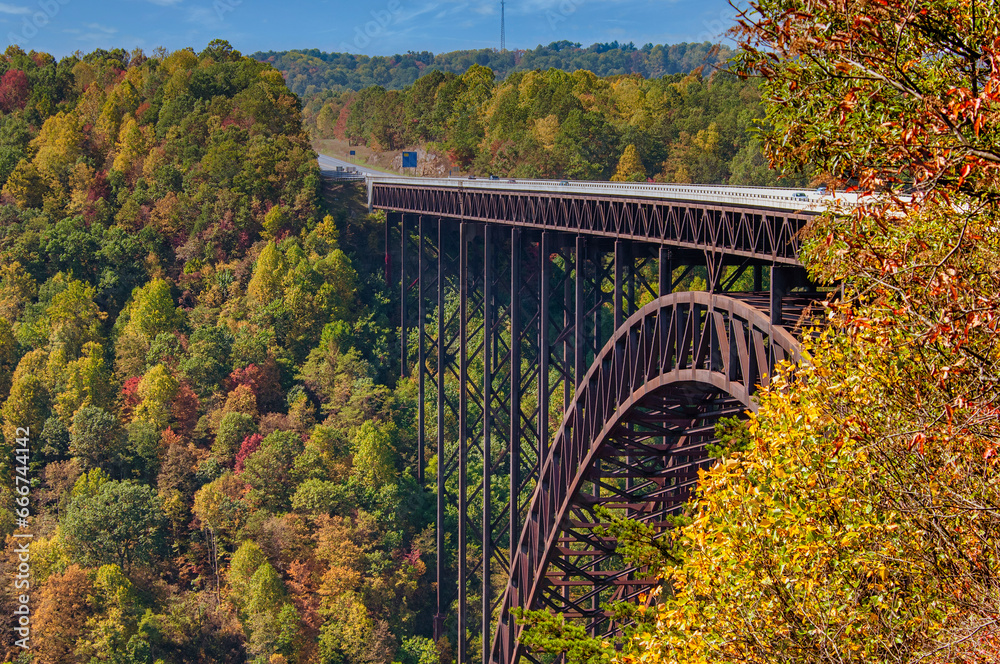 A colorful autumn landscape of the New River Gorge Bridge, a single-span steel arch structure and national landmark in the West Virginia mountains.