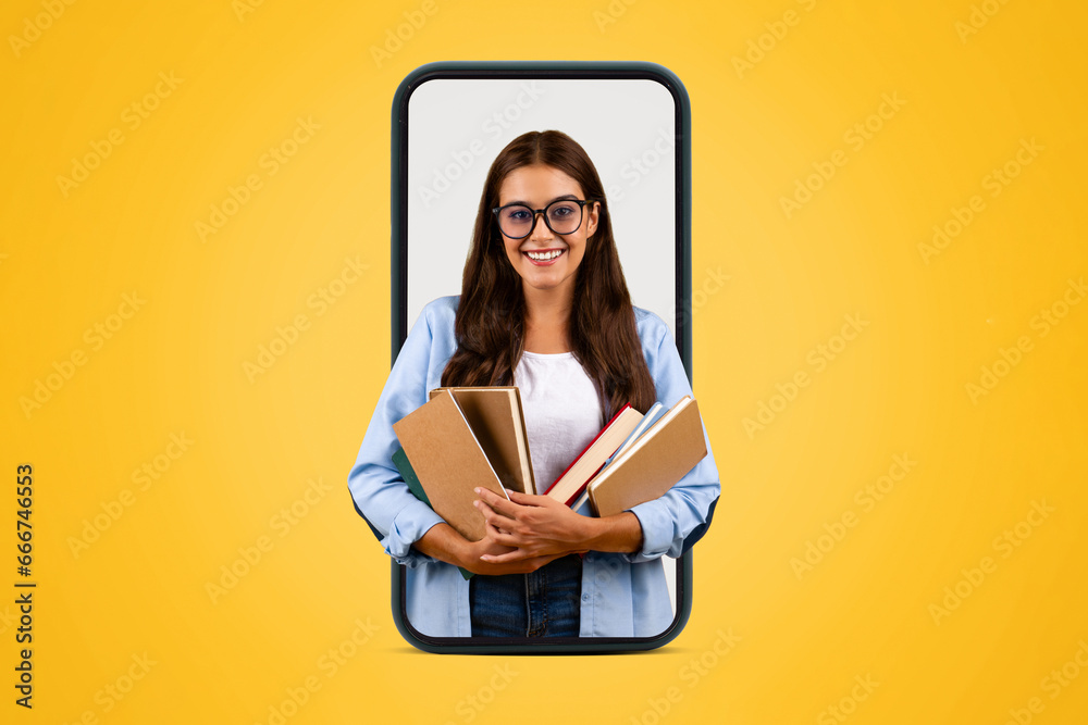 Smiling young student lady in glasses hold many books on big phone screen Smiling young student lady in glasses hold many books on big phone screen