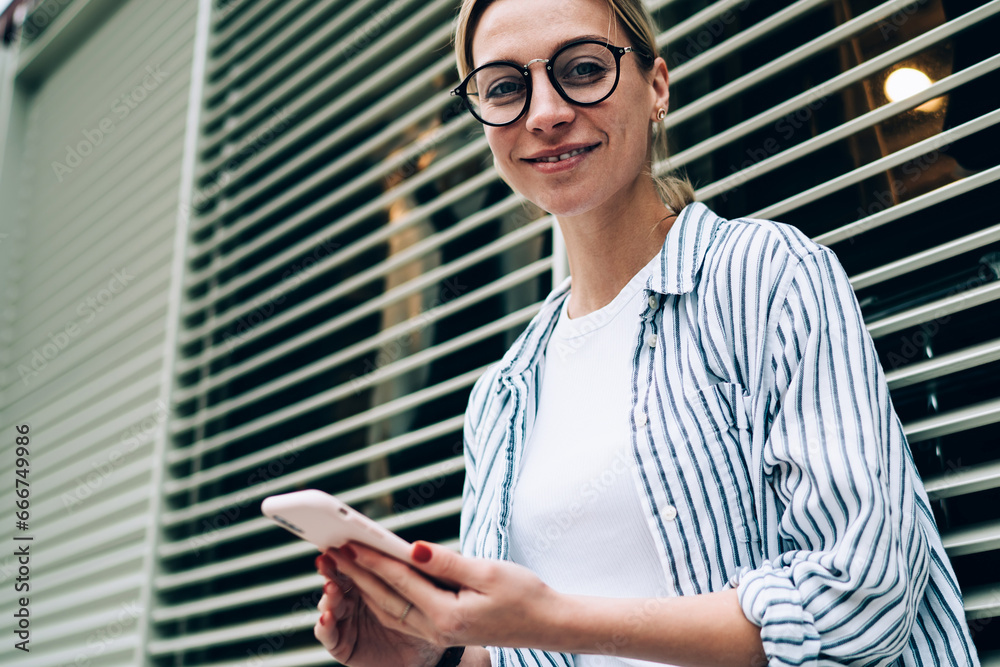 Beautiful women in casual clothes using smartphone and looking at camera Beautiful women in casual clothes using smartphone and looking at camera