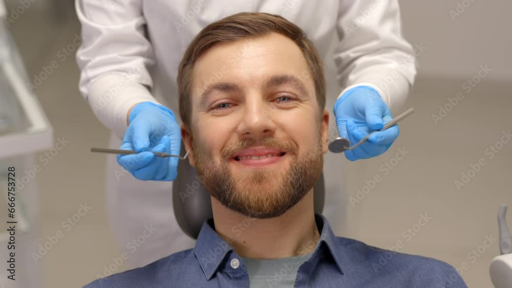 Portrait of happy man sitting at dentist chair in modern clinic and smiling. Patient enjoying dental treatment with professional dentist Portrait of happy man sitting at dentist chair in modern clinic and smiling. Patient enjoying dental treatment with professional dentist