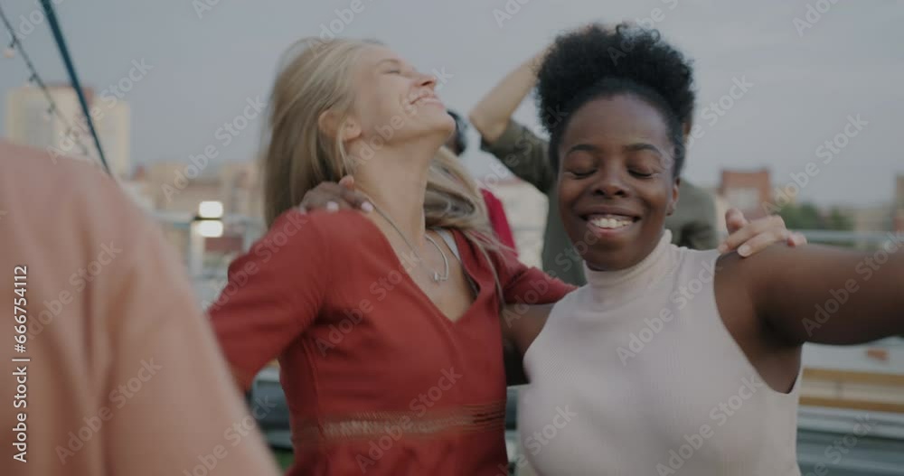 Slow motion of women friends African American and Caucasian dancing hugging enjoying rooftop party together. Friendship and happiness concept. Slow motion of women friends African American and Caucasian dancing hugging enjoying rooftop party together. Friendship and happiness concept.