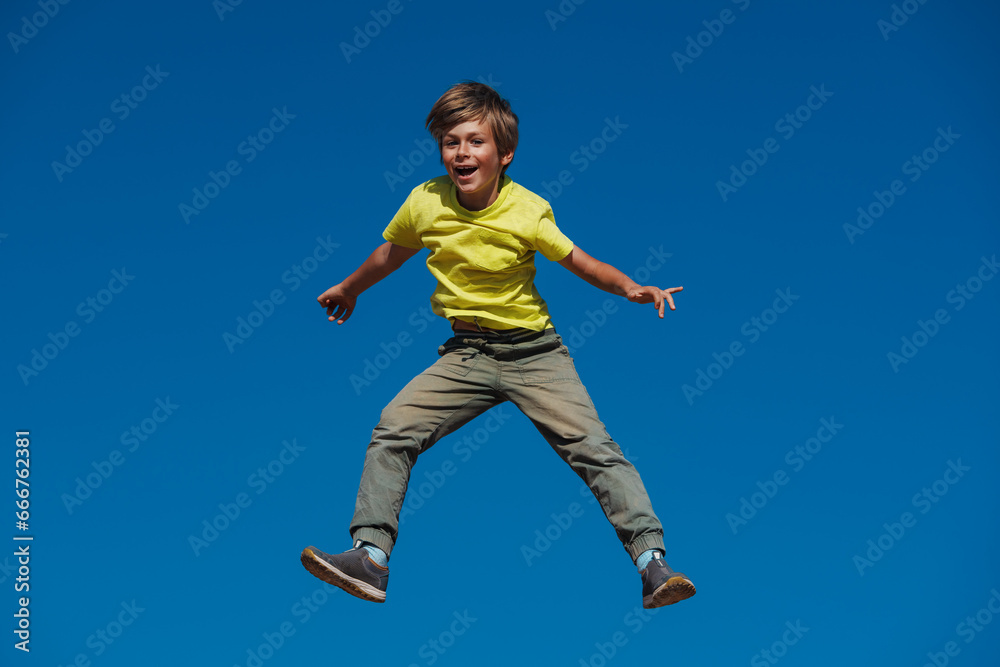 Happy boy jumping on blue sky background Happy boy jumping on blue sky background