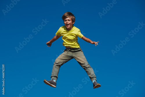 Happy boy jumping on blue sky background