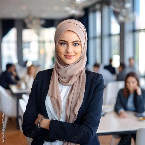 business woman with hijab looking at the camera in a boardroom people in the background