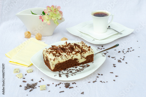 Stracciatellakuchen mit Schokoladensp  nen auf Schokoladenboden und Kaffeegedeck