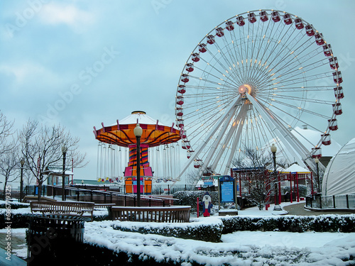 Snowy day at Navy Pier  Chicago with a lit Ferris wheel and carousel in view.