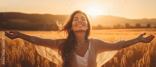 Backlit Portrait of calm happy smiling free woman with open arms and closed eyes enjoys a beautiful moment life on the fields at sunset