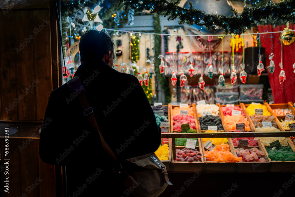 Young man with handbag looking at a Christmas market