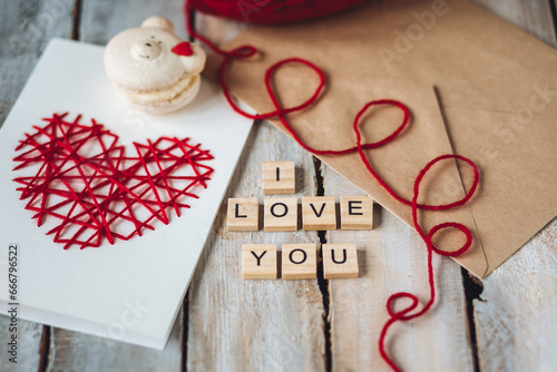 Beautiful wooden letterI love you on wooden background. Lovely cute handmade greeting card with red heart embroidering for Mothers or Saint Valentine's day, wedding or anniversary photo