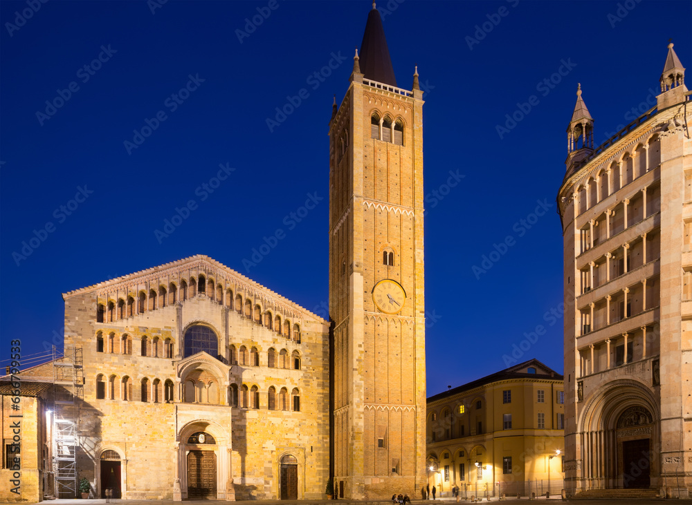 View of baptistery and cathedral of Parma illuminated at evening, Duomo square , Italy