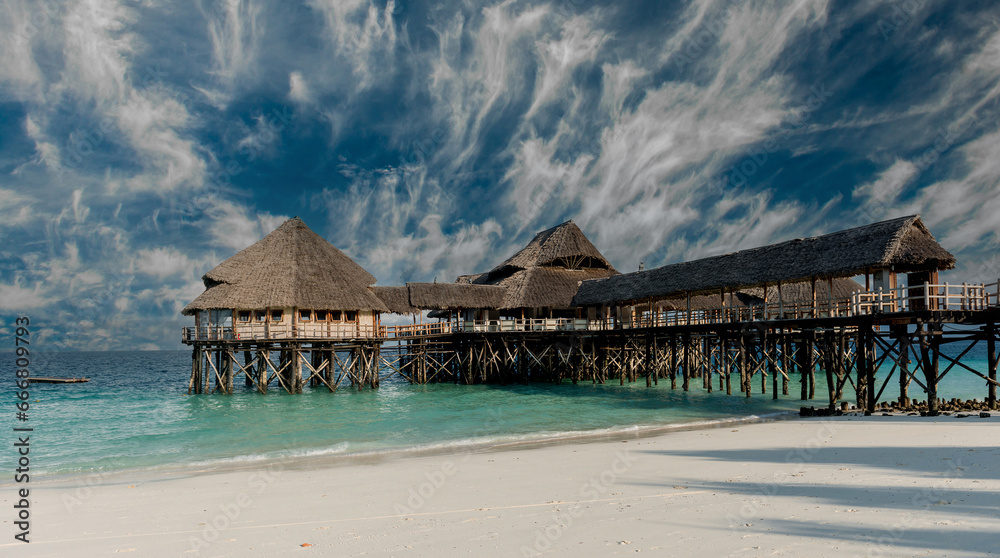 beautiful wooden pier with thatched huts in ocean