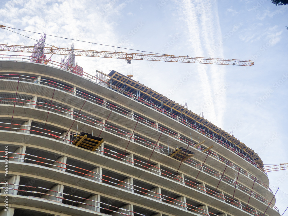 Fototapeta premium Construction of a modern high-rise building. Sides on the floors. Concrete frame of a building under construction. Construction in progress
