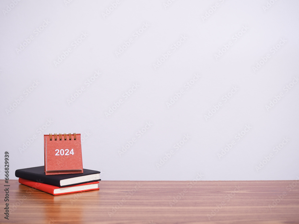 Study goals, 2024 Desk calendar on colorful hardcover book. The concept for Resolution, Goal, Action, Planning, and manage time to success graduate in New Year 2024