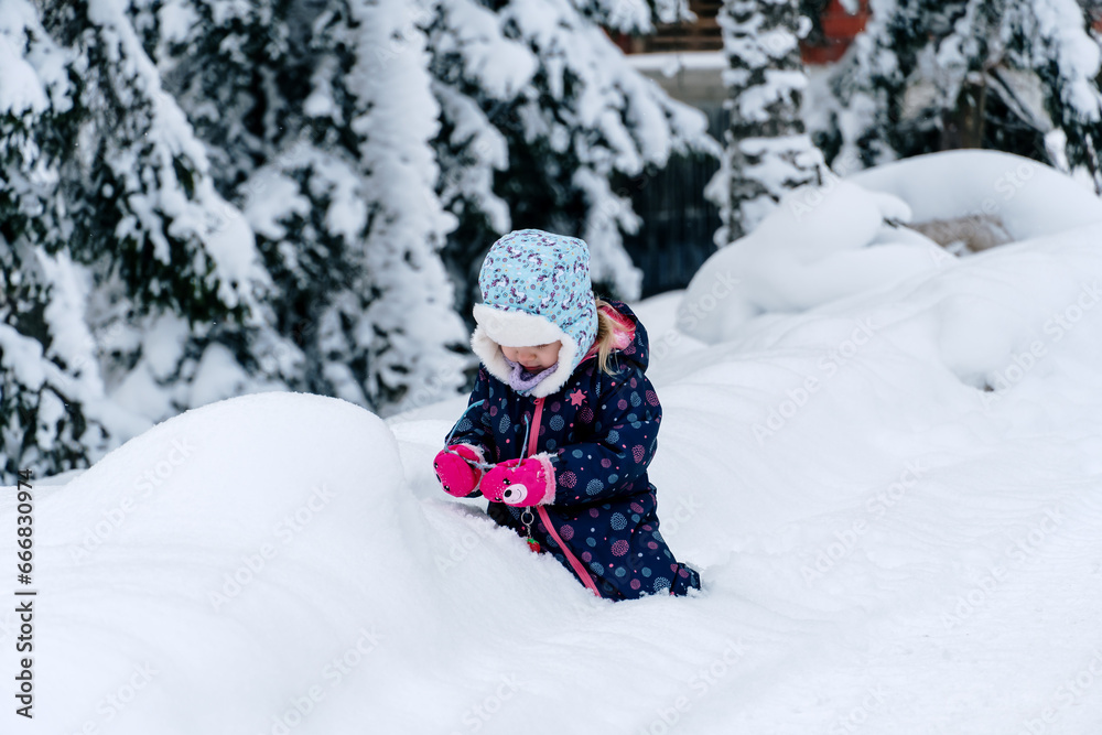 Little girl playing in a deep snow