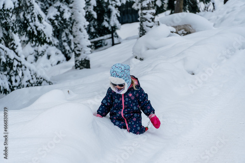 Little girl playing in a deep snow