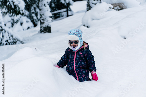 Little girl playing in a deep snow